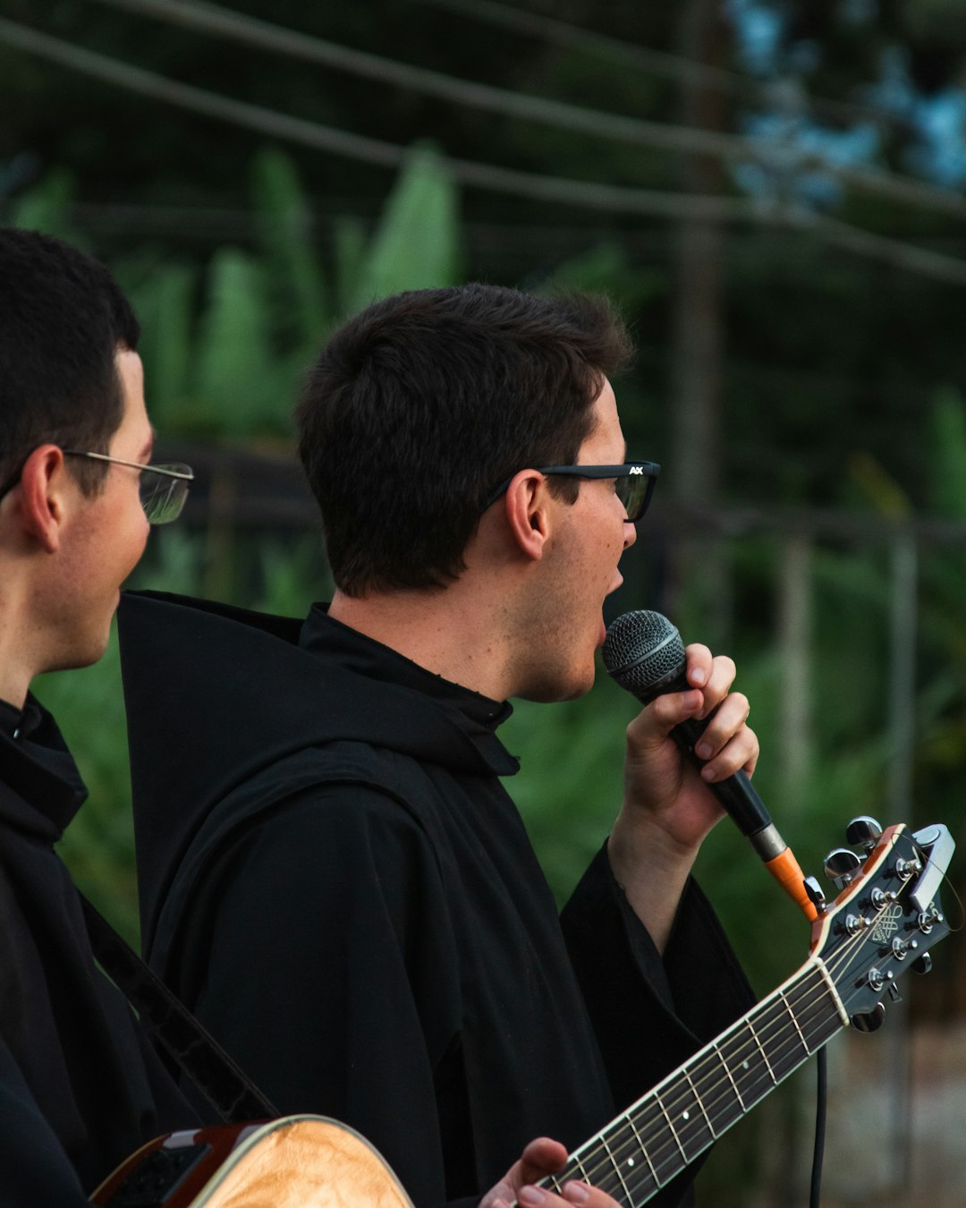 a man singing into a microphone while holding a guitar