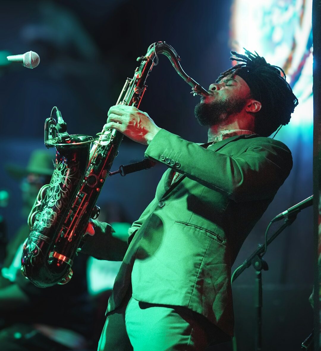 a man in a green suit playing a saxophone